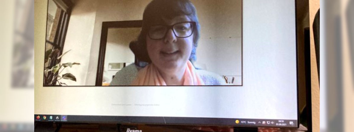 Eine Webcam zeichnet SMA-Betroffene Camilla auf, sodass sie im Bildschirm eines Monitors auf einem Arbeits-Schreibtisch zu sehen ist.