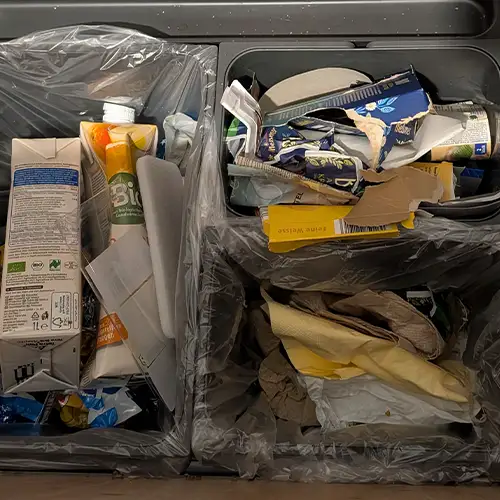 Ein Foto eines Mülleimers in einer Schublade mit separaten Fächern für Papier, Plastik und Restmüll.