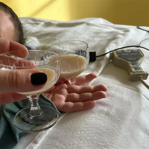 Ein Foto von Rosalie wie sie im Bett liegt und mit einem Glas anstößt.