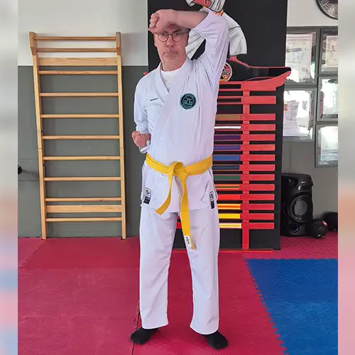 Ein Foto von Ulf, der seinen Karateanzug trägt und gerade die Technik „Age-Uke“ ausführt.