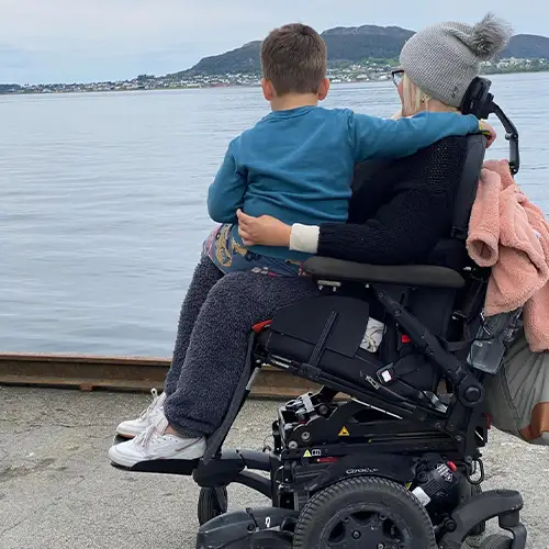 Ein Foto von Alina und ihrem Sohn, der auf ihrem Schoß sitzt – beide schauen zum Meer hinaus.