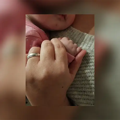 Sandra hält die Hand ihres Babys