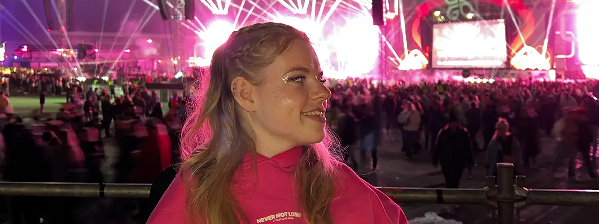 Ein Foto von Lilli, die auf einem Konzert ist – hinter ihr befinden sich viele Personen und eine Bühne.
